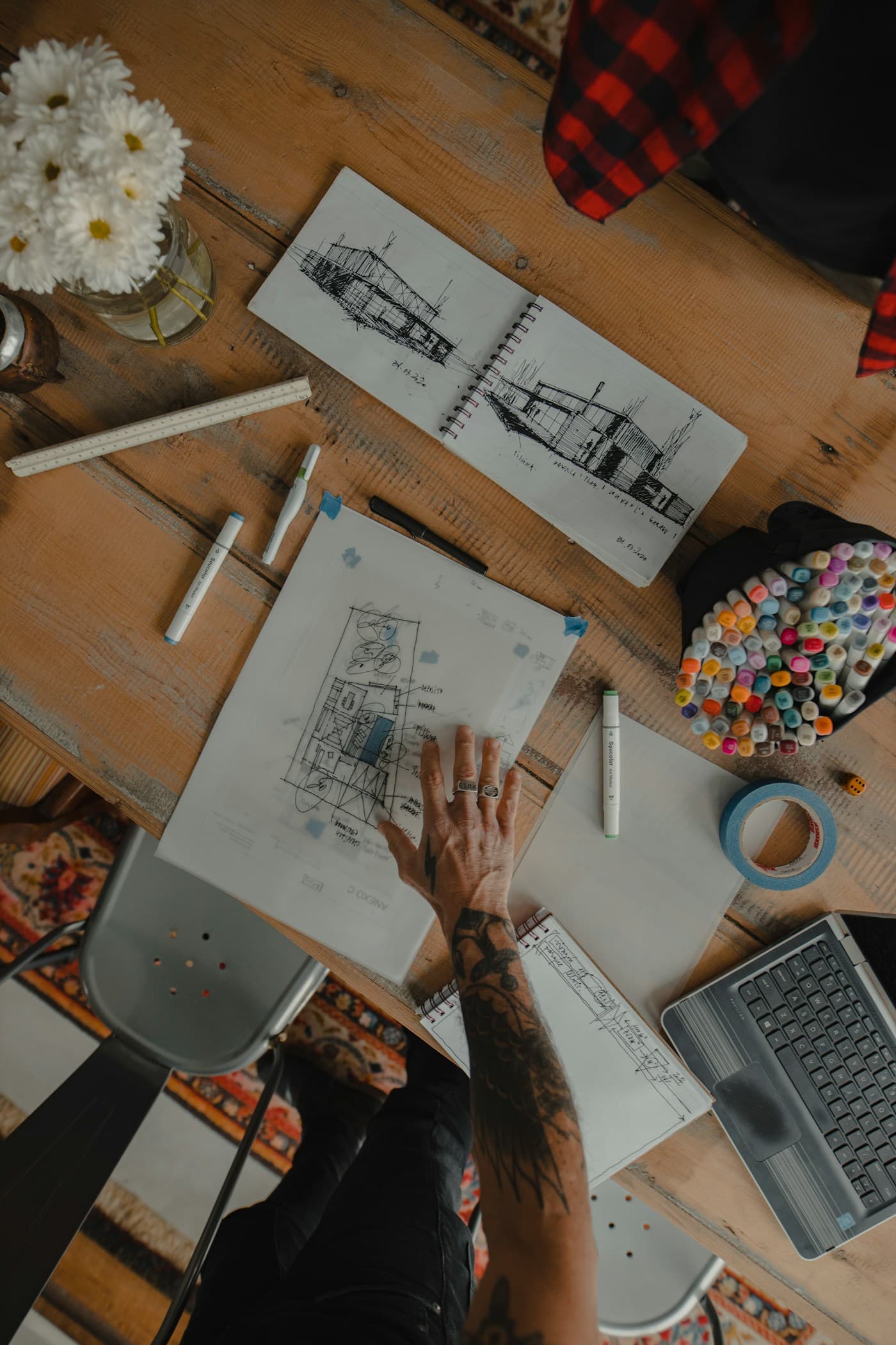 Architect working on hand sketches and concept plans at a design desk